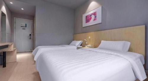 a large white bed in a hotel room at Jinjiang Inn Wenzhou Shuangyu The Terminal in Wenzhou