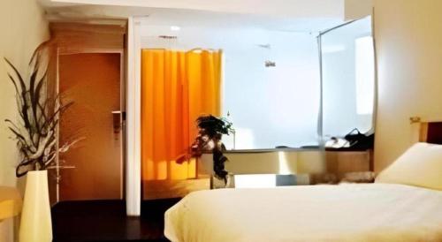 a bedroom with a white bed and a large window at Jinjiang Inn Wenzhou Shuangyu The Terminal in Wenzhou