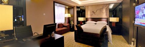 a hotel room with a bed and a flat screen tv at Zhongshan International Hotel in Zhongshan