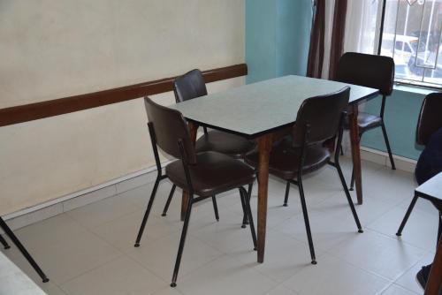une table et des chaises dans une pièce dans l'établissement New Swanga, à Nairobi