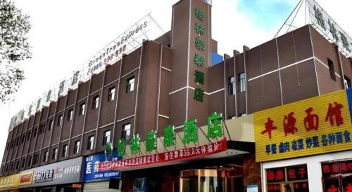 a large brown building with many signs on it at GreenTree Inn Haixi Geermu Southern suburbs Express Hotel in Golmud