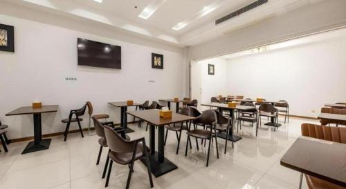 a restaurant with tables and chairs in a room at GreenTree Inn Nantong University Industrial Expo City Express Hotel in Nantong