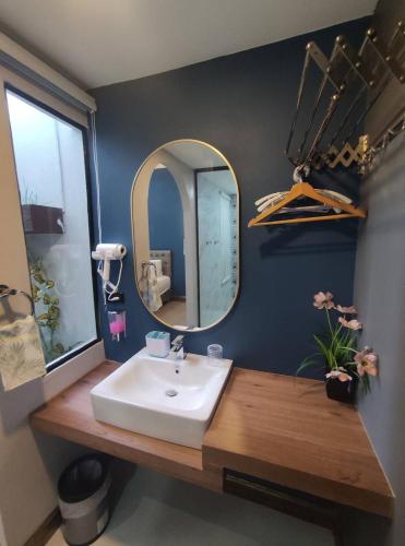 a bathroom with a sink and a mirror at อยู่สบายวิลล่า ยโสธร in Yasothon