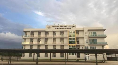 a white building with a sign on top of it at River Residence Saraburi Hotel in Sara Buri