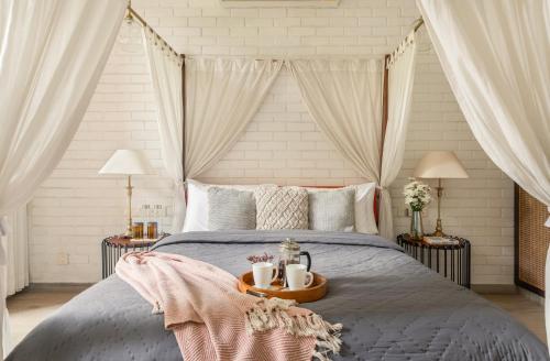 a bedroom with a bed and two tables with mugs on it at La Zamora, 3BHK Villas near Vagator & Anjuna Beach, North Goa with Private Pool, Garden, Terrace & Security in Assagao