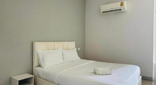 a white bed with a white pillow on top of it at River Residence Saraburi Hotel in Sara Buri