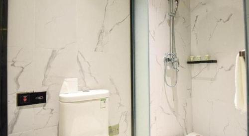 a white bathroom with a shower and a toilet at AURAYA BY SUNING NANJING XUZHUANG in Nanjing