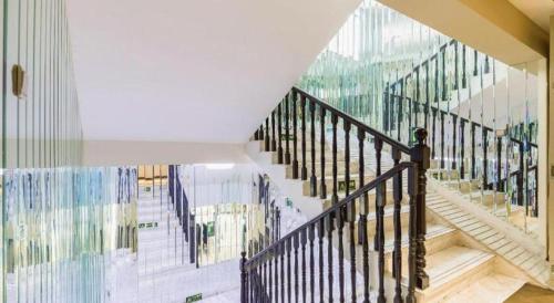 a staircase in a house with a glass wall at Xana Hotelle· Tianjin Railway Station Jinwan Square Binjiang Avenue in Tianjin