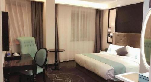 a hotel room with a bed and a desk at Xana Hotelle· Tianjin Railway Station Jinwan Square Binjiang Avenue in Tianjin