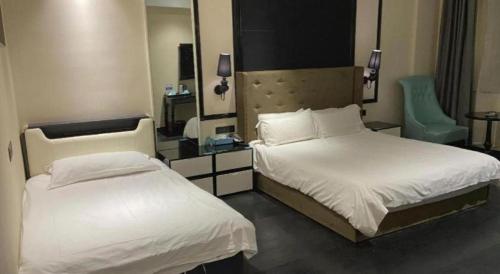 a hotel room with two beds and a mirror at Xana Hotelle· Tianjin Railway Station Jinwan Square Binjiang Avenue in Tianjin