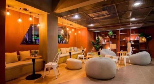 a living room with white chairs and a couch and tables at YUNIK-Shanghai Zhongshan Park Yan'an Xi Road in Shanghai