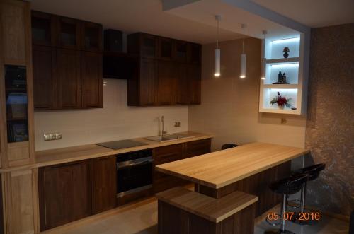 a kitchen with wooden cabinets and a wooden counter top at Apartament cetrum Mrągowo in Mrągowo