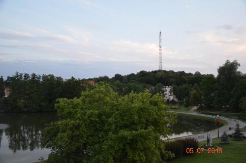 uma vista para um lago com uma torre de telemóvel ao fundo em Apartament cetrum Mrągowo em Mrągowo