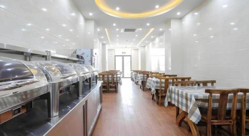 a restaurant with tables and chairs in a room at GreenTree Inn Jiaxin Puyuan Kaixuan Road in Jiaxing
