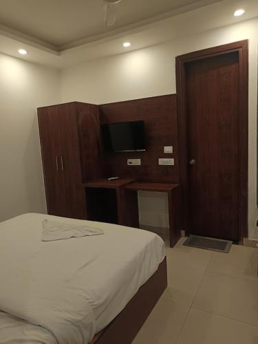 a hotel room with a bed and a television at Hotel harshu chanakyapuri in New Delhi