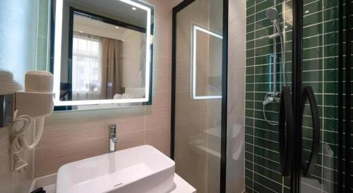 a bathroom with a sink and a glass shower at GreenTree Inn Express Hebei Shijiazhuang Zhengding County Changshan Dong Road in Shijiazhuang