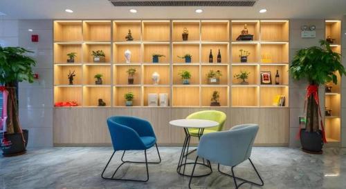a room with a table and chairs and shelves with plants at GreenTree Inn Express Hebei Shijiazhuang Zhengding County Changshan Dong Road in Shijiazhuang