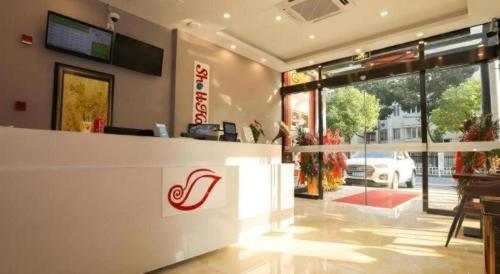a restaurant with a counter with a sign on it at Shell Shanghai Jiading Nanxiang Town Minzhu Street Hotel in Shanghai