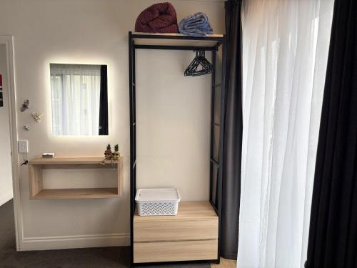 a bathroom with a mirror and a mirror shelf at Entire Apartment 21st Floor Queen Street in Auckland