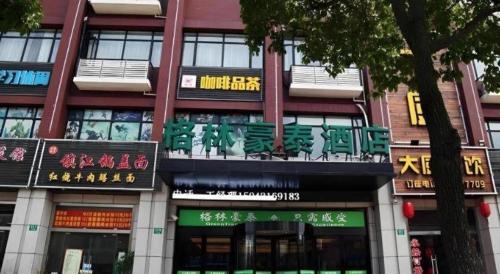 a building with signs on the side of it at GreenTree Inn Shanghai Fengxian District Xiaotang Metro Station in Shanghai