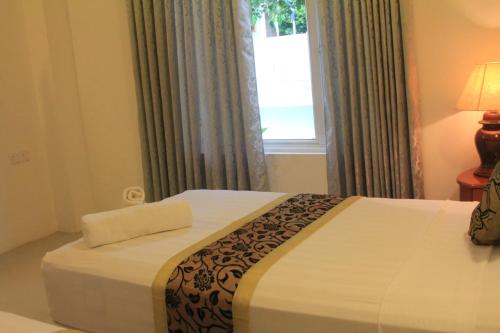 a bedroom with a large bed with a window at Ras Rana Lodge in Rasdu