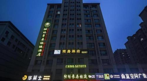 a tall building with a clock on top of it at GreenTree Inn Weifang Kuiwen District Beiwang Jiale in Weifang