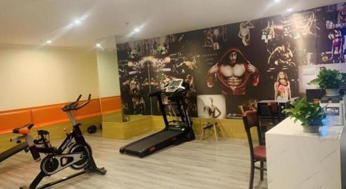 a gym with exercise bikes and a wall mural at Shell Shanghai Songjiang District Xinqiao Town Xinqiao Hotel in Chunshen