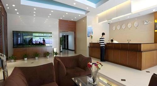 a man standing at a counter in a lobby at Shijia Inn On the Bund in Shanghai