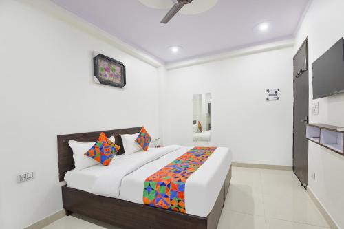 a bedroom with a bed in a white room at FabHotel DD Green Residency in New Delhi
