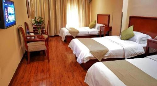 a hotel room with three beds and a television at GreenTree Inn Yixing Zhangzhu Express Hotel in Xinchating