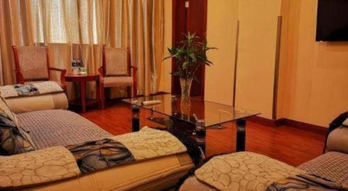 a living room with a glass table and a couch at GreenTree Inn Yixing Zhangzhu Express Hotel in Xinchating