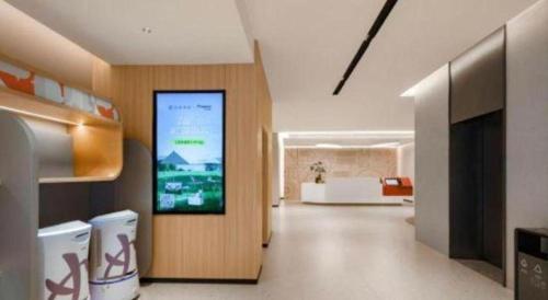 a living room with a large screen on the wall at Home Inns Plus Shanghai Xujiahui Branch in Shanghai