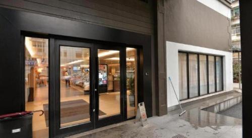 a building with glass doors on the side of it at Home Inns Plus Shanghai Xujiahui Branch in Shanghai