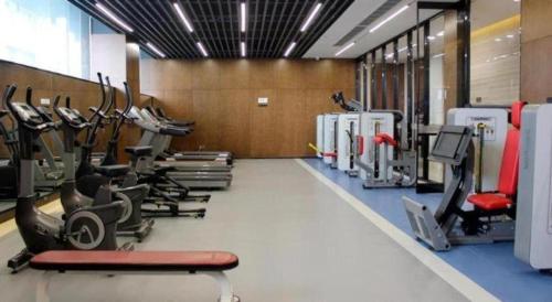 a gym with several treadmills and cardio machines at Zhangjiagang Zhonglian GDH International Hotel in Zhangjiagang