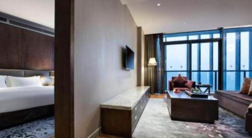 a hotel room with a bed and a couch at Fliport Hotel Zhangzhou Yuanshan in Zhangzhou