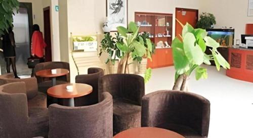 a room with chairs and tables and plants at GreenTree Inn Jinan Bus Terminal in Jinan