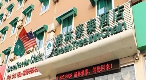 a building with an american flag on top of it at GreenTree Inn Jinan Bus Terminal in Jinan