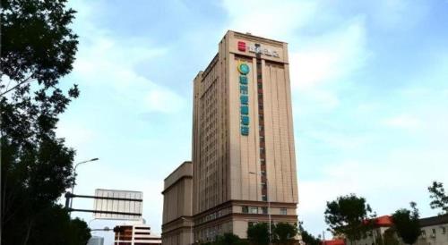 a tall building with a sign on the side of it at Echarm Hotel Jinan Railway Station Daming Lake in Jinan