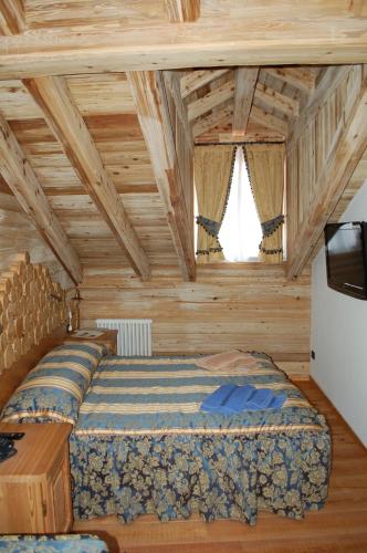 a bedroom with a bed in a room with wooden ceilings at Residenza La Corte Dei Toldi in Terzolas