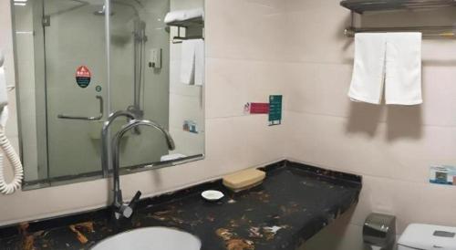 a bathroom with a sink and a shower and a toilet at GreenTree Inn Xinjiang Uygur Autonomous Region Korla Bazhou Bus Terminal Beishan Road Express Hotel in Korla