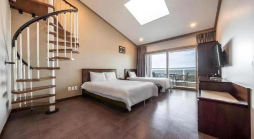 a hotel room with two beds and a staircase at Sea View Hotel in Jeju