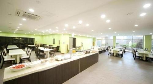 a large room with tables and chairs and a cafeteria at Sea View Hotel in Jeju