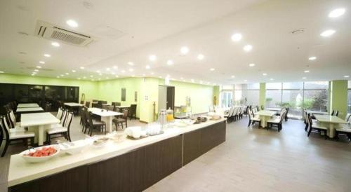 a large room with tables and chairs and a cafeteria at Sea View Hotel in Jeju