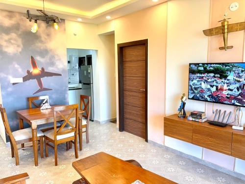 Un comedor con una mesa y un televisor. en Vintage 2BHK Apartment - Gym, Pool & Amenities - Mangrove View, en Candolim