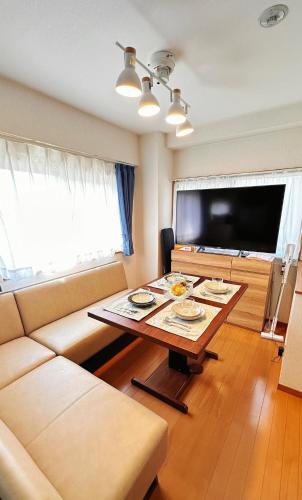 ein Wohnzimmer mit Couch und Tisch in der Unterkunft HYGGE HOUSE Tabibitonoie - Vacation STAY 61173v in Kashiwa