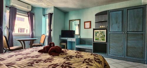 a stuffed animal is laying on a bed in a bedroom at Pension Zum Ross in Karon Beach
