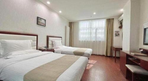 a hotel room with two beds and a television at GreenTree Inn Yinchuan Pedestrian Street East Liqun Street Express Hotel in Yinchuan