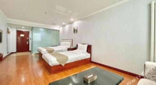 a bedroom with a bed and a couch and a table at GreenTree Inn Yinchuan Pedestrian Street East Liqun Street Express Hotel in Yinchuan