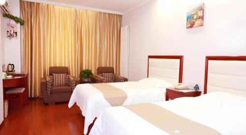 a hotel room with two beds and a chair at GreenTree Inn Yinchuan Pedestrian Street East Liqun Street Express Hotel in Yinchuan