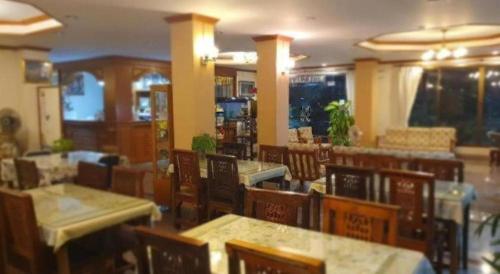 a dining room with tables and chairs in a restaurant at Ritzy House Hotel in Chumphon